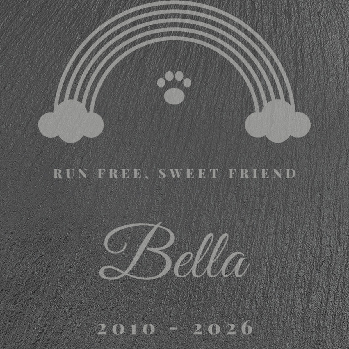 Close-up of the engraved rainbow, paw print, Run Free, Sweet Friend and the name Bella on the Rainbow Bridge pet memorial slate