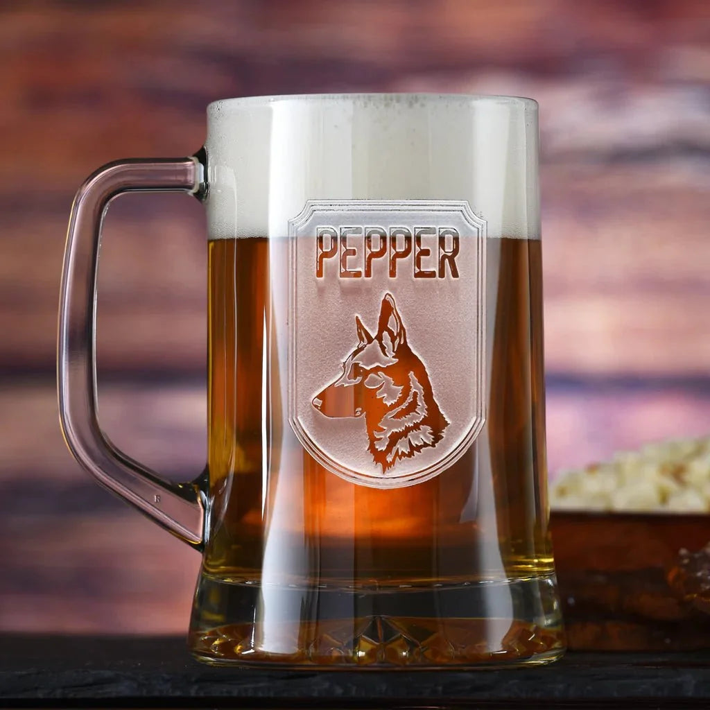 Top Dog beer mug full of amber beer with the carved German Shepherd shield and the name Pepper, on a dark wood bar with snacks behind