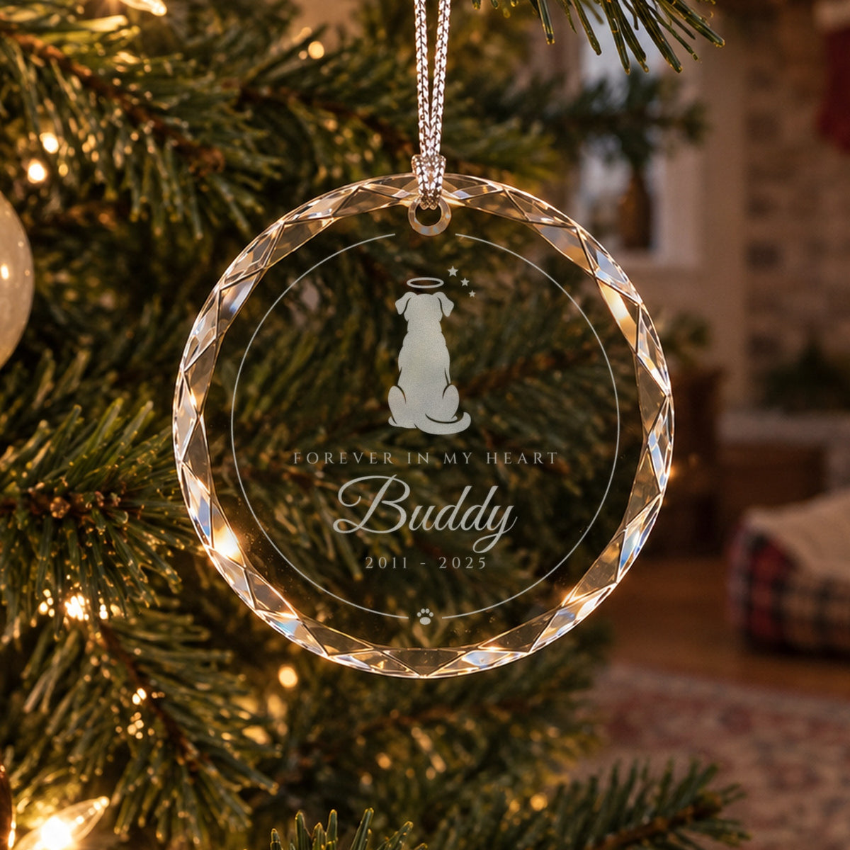 Personalized dog memorial ornament in faceted glass on a Christmas tree near an empty pet bed, engraved Forever in My Heart, Buddy