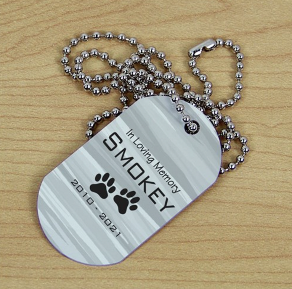 Personalized metal pet memorial dog tag necklace with engraved name and dates.
